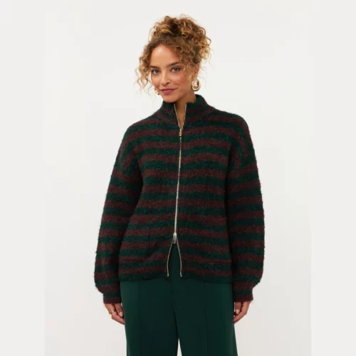 Model draagt Ydence cardigan Suzanne met groen-bordeaux strepen en ritssluiting, gecombineerd met donkergroene pantalon Solange