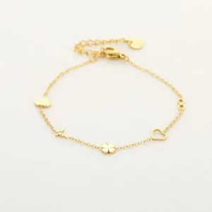 Goudkleurige schakelarmband met hartjes, klavertje vier en infinitysymbool op een lichte ondergrond.